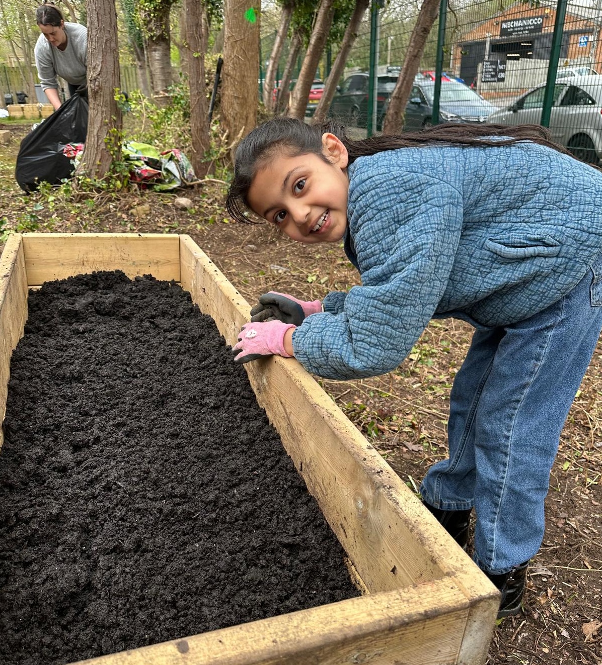 Huntingdon Allotment pupil adding soil to raised bed